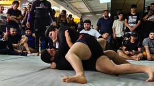 Atletas compitiendo en el Open de Cintas Blancas de Brazilian Jiu-Jitsu organizado por Renegades SOJ, rodeados por el público.